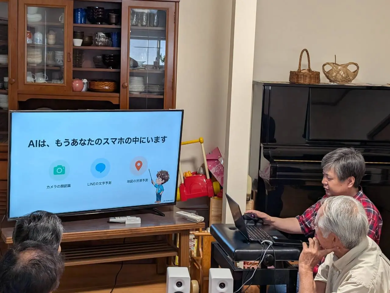 講師がノートパソコンを操作しながら、AIがすでにスマートフォンの中で使われていることを解説している様子